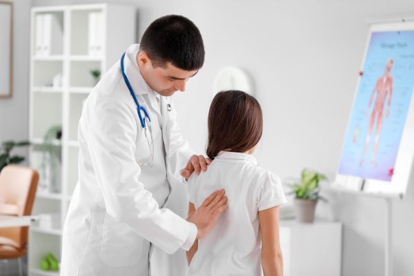 A Male doctor checking the back of the patient