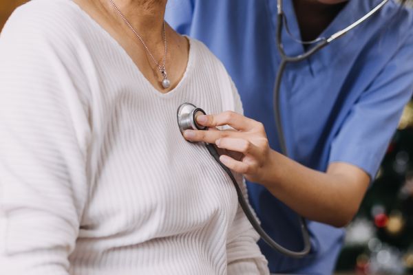 A doctor typing on the laptop with the chart on the desk