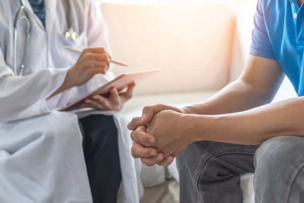 A doctor is examining the patient's neck.


