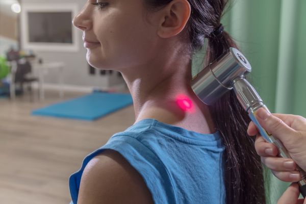 A girl undergoing laser pain treatment for her back.


