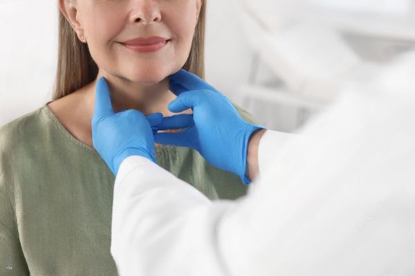 A doctor is examining the patient's neck.


